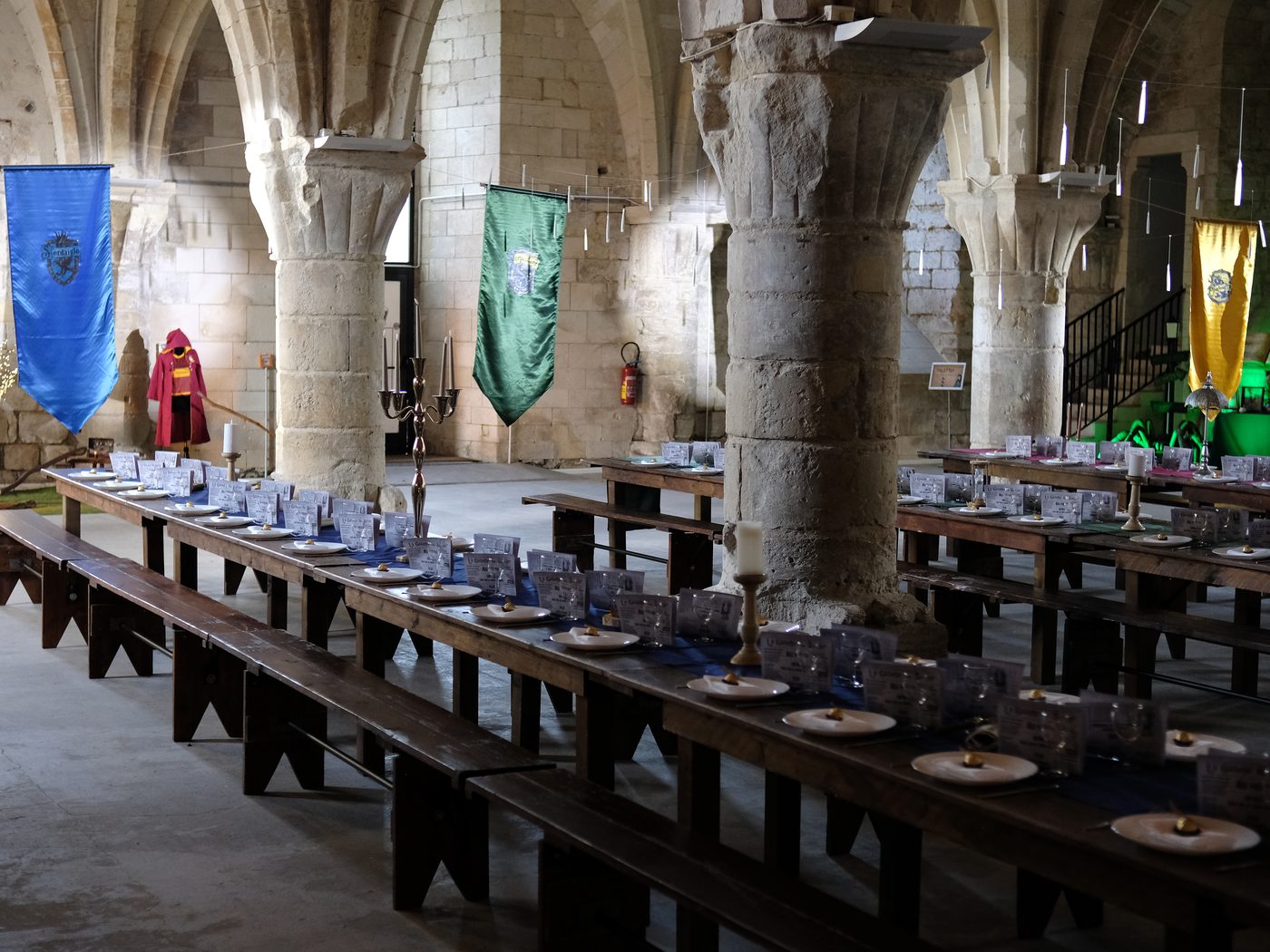 Banquet dans une salle voûtée décorée aux couleurs d’une école de sorcellerie