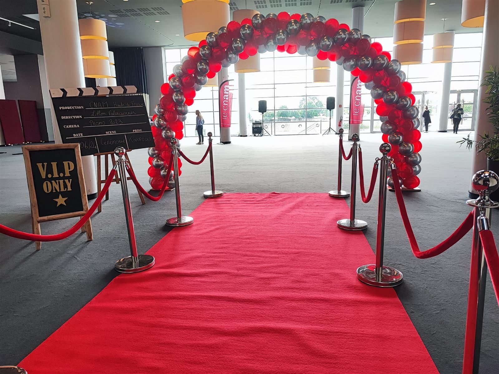 Tapis rouge et arches de ballons à l’entrée d’une cérémonie