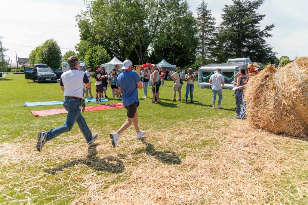 Olympiades d’entreprise : course sur la paille devant les structures gonflables