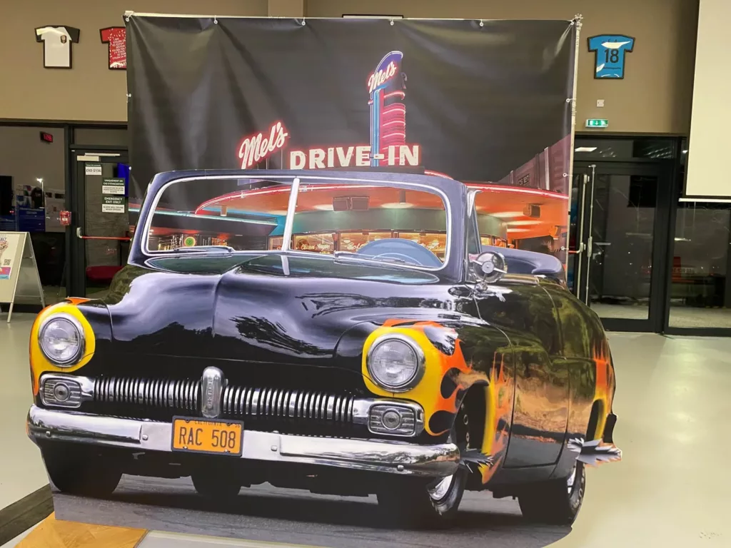 Voiture américaine en trompe-l'œil devant une toile Drive-in