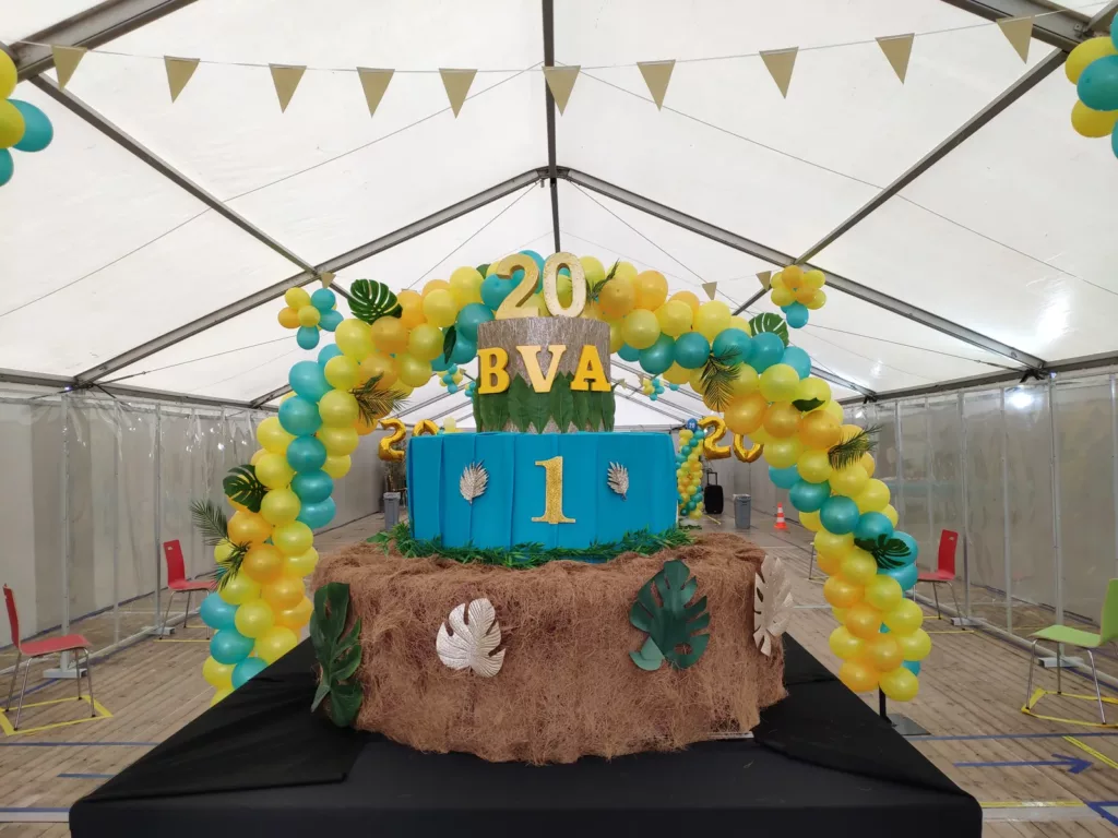 Arche de ballons jaunes et verts sous chapiteau