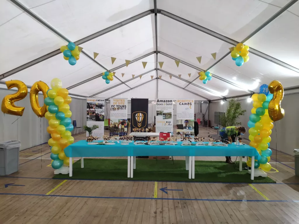 Table d'accueil et colonnes de ballons jaunes et verts