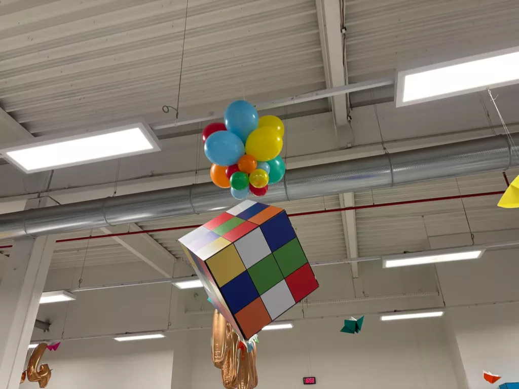Cube géant multicolore suspendu sous des ballons