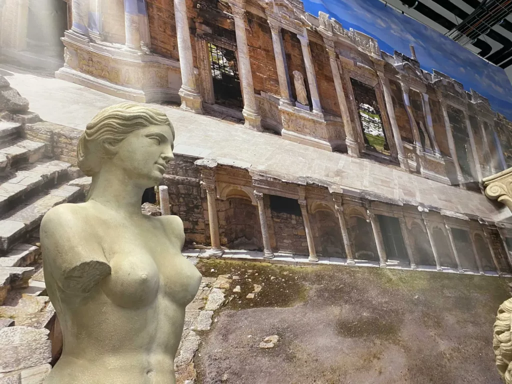 Statue antique devant une toile de théâtre grec