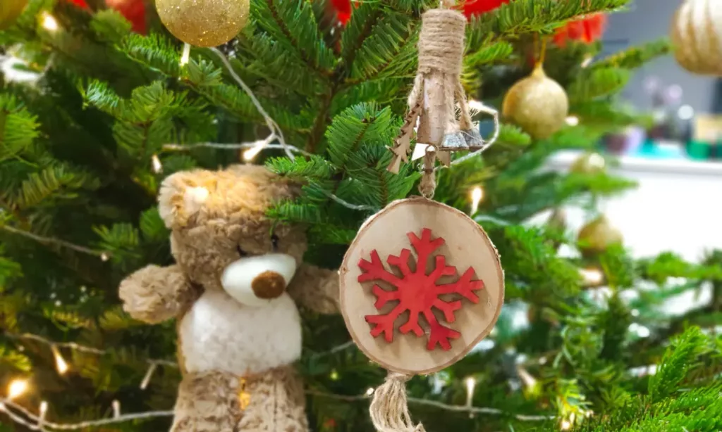 Ourson et décoration en bois dans le sapin