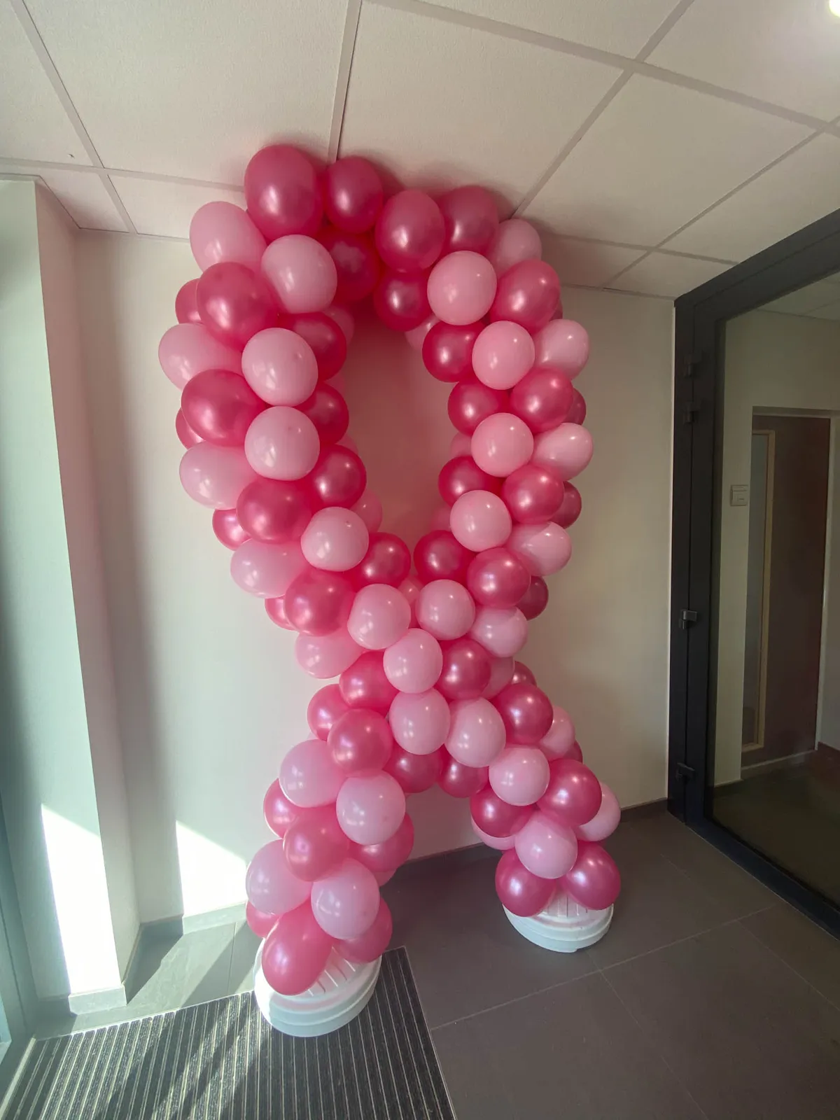 Ruban rose en ballons devant une baie vitrée