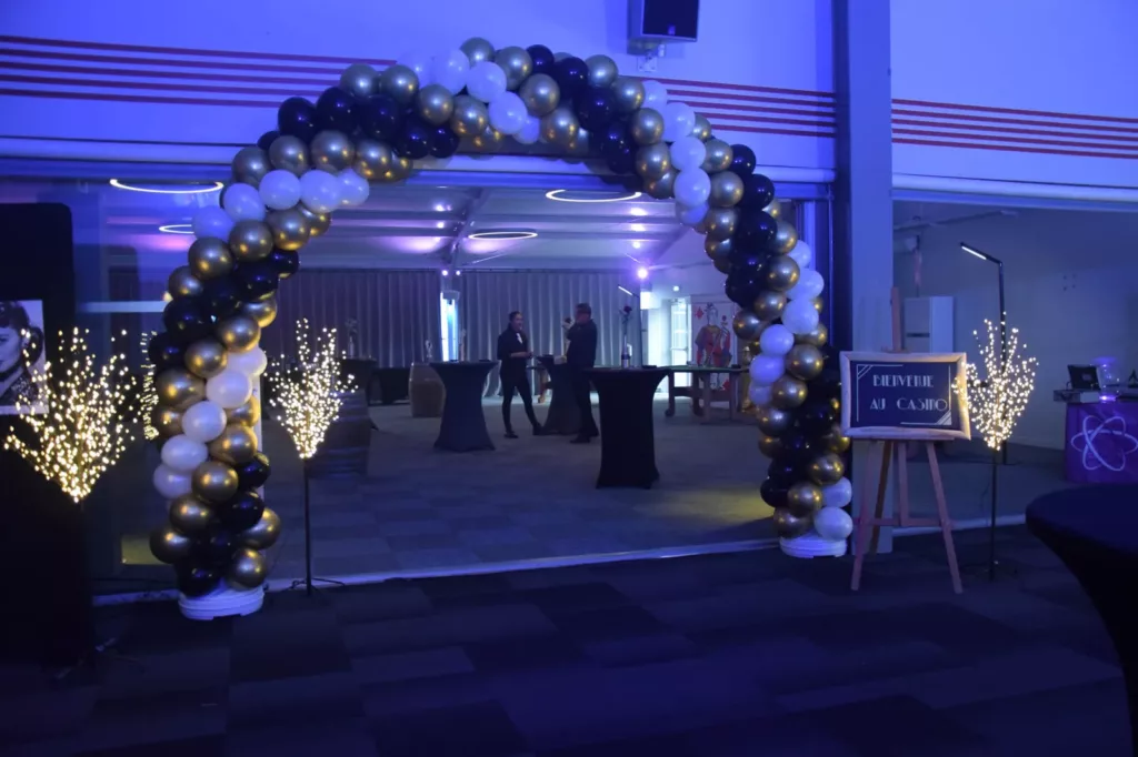 Arche de ballons et arbres lumineux à l'entrée de la salle