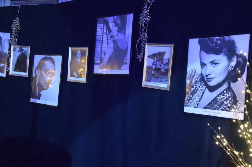 Exposition de portraits noir et blanc sur pendrillons noirs