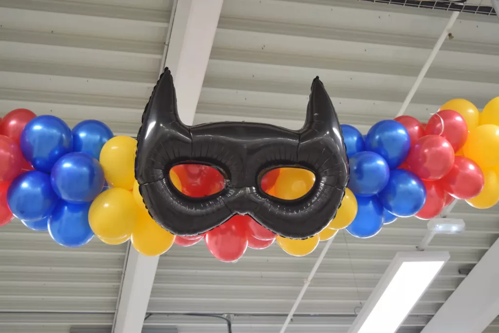 Masque de super-héros et ballons rouges, bleus et jaunes