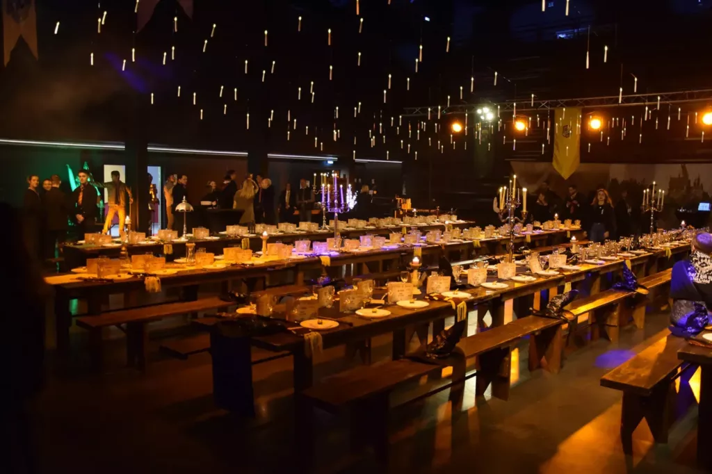 Grande salle aux bougies flottantes et longues tables